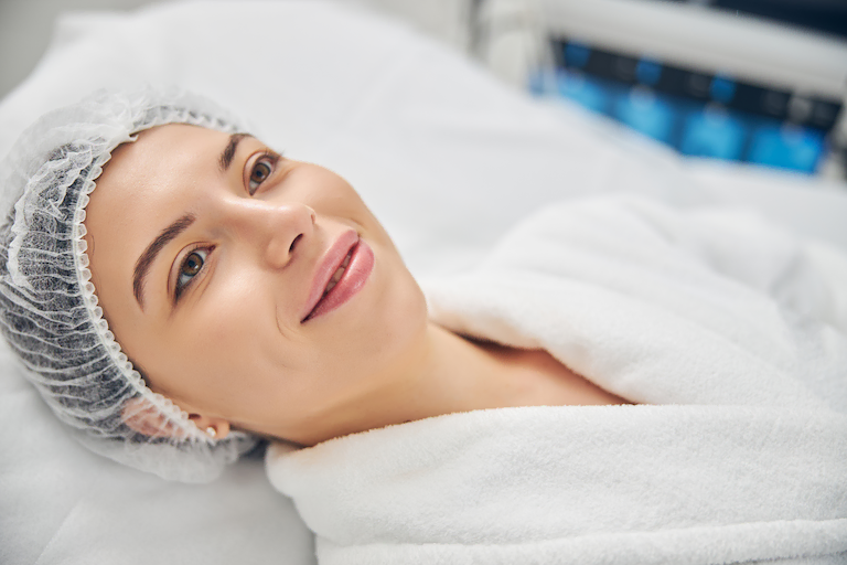 comment se déroule une intervention avec le dr layoun à aix en provence clinique axium Femme souriante allongée en clinique esthétique