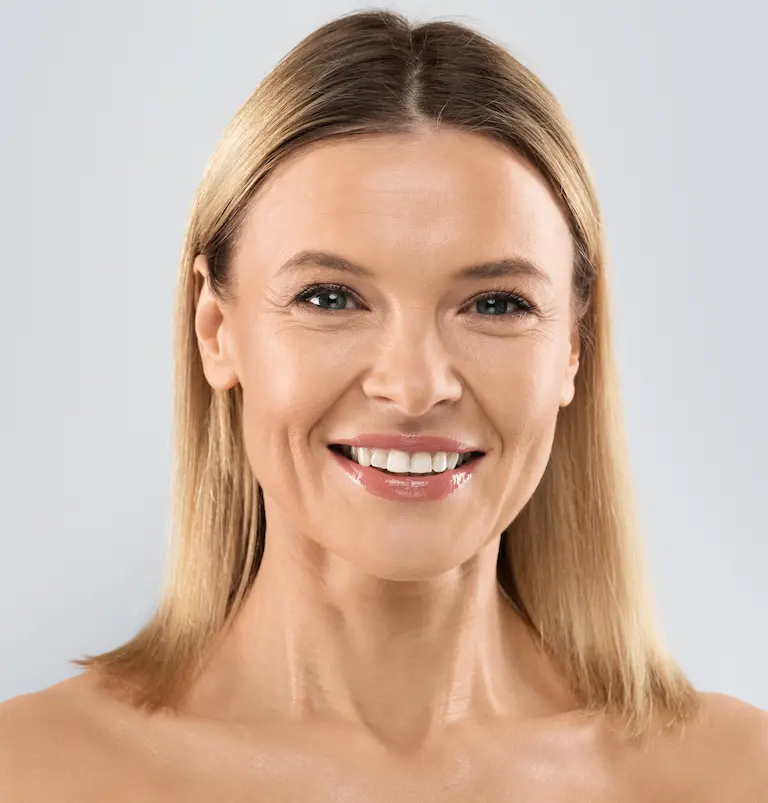 pourquoi les ligaments sont la clé du rajeunissement deep plane lift à aix en provence Portrait d’une femme blonde souriante en gros plan